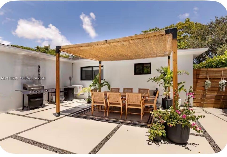 Outdoor patio featuring a custom wood-post pergola with a woven shade canopy, large-format concrete pavers with crushed stone borders, and horizontal 