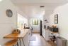 Kitchen featuring wood-finish butcher block counters, white cabinetry, integrated sink with matte black faucet, and light-toned wood-finish flooring