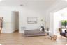Light-toned wood-finish flooring, crisp white walls, and decorative crown molding