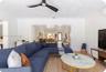 Open-concept interior featuring light wood-finish flooring, a contemporary three-blade ceiling fan, crown molding, and a wall-mounted ductless climate