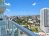 Elevated private balcony featuring glass panel railings and expansive urban scenery