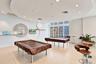 Recreation space featuring large-format tile flooring, a circular dropped ceiling with recessed lighting, floor-to-ceiling windows, and decorative wal