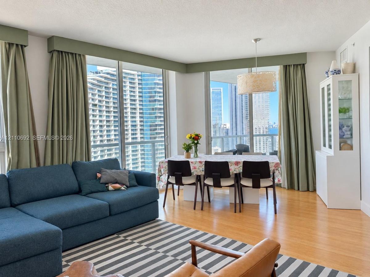 Floor-to-ceiling glass windows, wood-finish flooring, and built-in custom window valances
