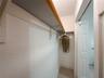 Reach-in closet featuring built-in shelving with wood trim and a bifold door