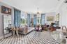 Living space featuring crown molding, multiple windows with decorative brass curtain rods, checkered tile flooring, and a central pendant light fixtur