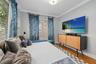 Room featuring wood-finish flooring, crown molding, and two windows with horizontal blinds and metal curtain rods