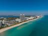 Aerial perspective of a coastal environment featuring extensive sandy beaches, expansive shoreline, and direct proximity to open water