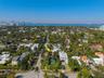 Aerial perspective featuring a private swimming pool, mature palm trees, and manicured perimeter hedging