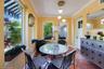Sunroom featuring terracotta tile flooring, crown molding, multi-pane windows, and a three-light modern pendant fixture
