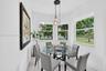Sun-filled nook featuring triple-pane corner windows, pendant lighting with glass shades, and neutral floor tiling