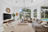 Living space featuring high ceilings, recessed lighting, crown molding, a central ceiling fan, and floor-to-ceiling windows with sliding glass doors