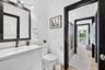 Bathroom featuring a white vanity with an integrated sink, dark-finish faucet, framed wall-mounted mirror, and black door casings