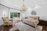 Tray ceiling with recessed lighting, dark wood-finish flooring, and sliding glass doors opening to an exterior swimming pool