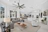 Open-concept living area featuring high ceilings, recessed lighting, large-format tile flooring, a chef's kitchen with a waterfall island, and a multi