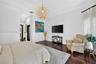 Tray ceiling, dark wood-finish flooring, crown molding, and woven spherical pendant lighting
