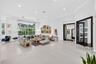 Spacious interior featuring large-format tile flooring, recessed lighting, expansive floor-to-ceiling windows, and French doors with dark-finished tri