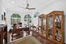 Wood-finish flooring, recessed lighting, ceiling fan, and arched windows with crown molding