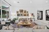 Living area featuring high ceilings, large-format tile flooring, recessed lighting, and expansive floor-to-ceiling windows
