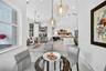 Open-concept interior featuring large-format tile flooring, recessed lighting, expansive windows, and tiered glass pendant fixtures over the dining ar