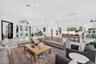Open-concept interior featuring large-format tile flooring, recessed lighting, arched window accents, double glass-paned doors, and a kitchen island w