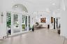 Foyer featuring large-format tile flooring, high ceilings, double glass entry doors with a decorative arch transom window, and crown molding