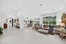 Open-concept living space featuring oversized neutral floor tile, recessed lighting, crown molding, and expansive floor-to-ceiling glass panel windows