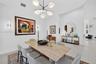 Multi-arm contemporary chandelier with opal glass shades, neutral large-format tile flooring, and integrated wall-mounted linear light fixtures