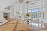 Grand atrium featuring a coffered ceiling, polished wood-finish flooring with intricate inlay, soaring structural columns, expansive floor-to-ceiling 