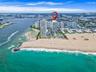 High-rise building featuring direct oceanfront access, private swimming pool, landscaped grounds, and proximity to the coastline