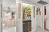 Built-in wet bar featuring glass shelving, mirrored backsplash, and under-counter cabinetry