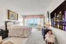 Floor-to-ceiling windows with balcony access, wall-to-wall carpeting, and neutral paint palette