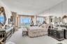 Floor-to-ceiling windows, full-wall mirrored accent, and wall-to-wall carpeting