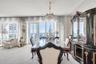 Floor-to-ceiling windows, crystal chandelier, mirrored wall paneling, and a glass-paneled door