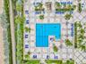 Geometric swimming pool with lap lanes and integrated stairs, surrounded by extensive patterned stone tiling, tropical landscaping, and mature palm tr