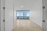 Polished stone flooring, expansive floor-to-ceiling glass sliding doors, and private balcony access