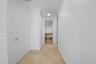 Hallway featuring neutral tile flooring laid on a diagonal, crisp white walls, crown molding, and recessed lighting