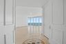 Interior entry featuring dual-panel doors, large-format tile flooring with a circular stone inlay medallion, and floor-to-ceiling glass windows offeri