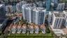 Aerial perspective of a high-rise residential complex featuring a tiered building design, terra-cotta roof tiles, private ground-level patio pools, an