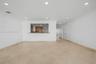 Open floor plan featuring tile flooring, recessed lighting, and a kitchen pass-through with a breakfast bar