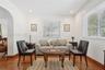Room featuring wood-finish flooring, recessed lighting, white walls, horizontal window blinds, and an arched architectural opening