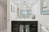 Bathroom featuring a dark wood-finish vanity with an integrated basin, white solid-surface countertop, recessed lighting, and a floor-to-ceiling mirro