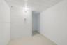 Enclosed space featuring painted masonry walls, a concrete floor, exposed ceiling joists, and an electrical wall outlet