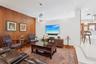 Wood-paneled accent wall, recessed lighting, glass pendant fixture, hardwood flooring, and tiered floor elevation
