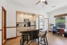 Kitchen featuring custom light-finish cabinetry, recessed lighting, tile flooring, and a built-in island with decorative detailing