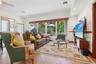 Living area featuring large-format ceramic tile flooring, recessed lighting, and a panoramic window wall with wood-slat blinds