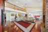 Expansive Family Room with a view of the Dining Room and second floor gallery. Wood-burning brick fireplace