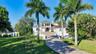 Looking at the property from the private road, fruit trees line the paved driveway