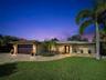 Front of home has paver driveway and beautifully landscaped.