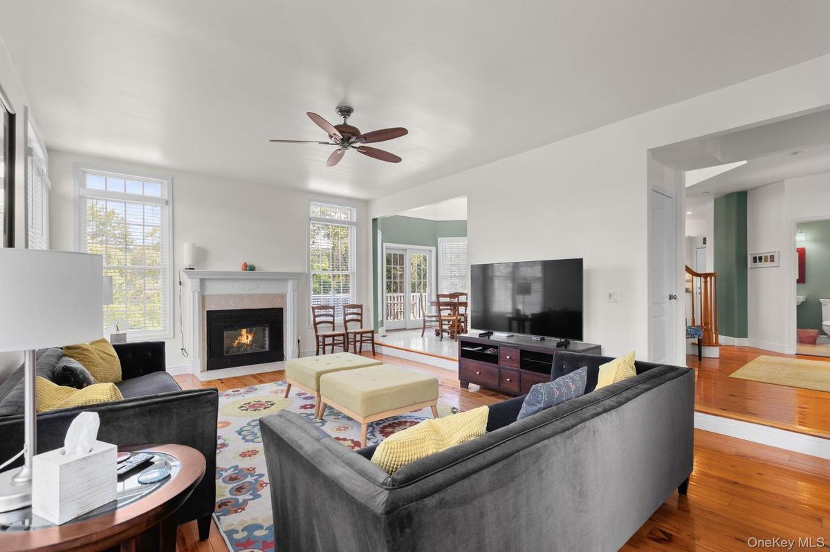The spacious living room is complemented by a beautifully adorned fireplace, adding warmth and inviting ambiance—perfect for cozy evenings on cold win