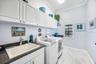 Laundry room with utility sink and storage cabinets